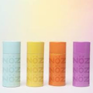 Four NOZ sunscreen sticks in electric neon blue, yellow, orange, and purple, plain background